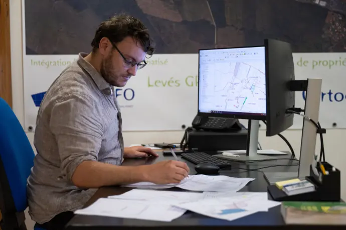 SIG et cartographie forestière : la précision au service de la gestion durable – ARGEFO Géomaticien en train de travailler sur un logiciel SIG pour cartographier des parcelles forestières dans les bureaux d’ARGEFO.